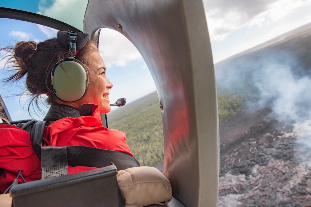 A woman taking in the views during a helicopter tour over the Island of Hawaii