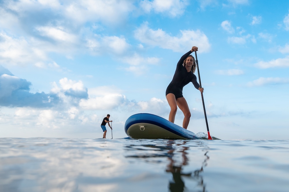 Two people on stand-up paddleabords in the ocean