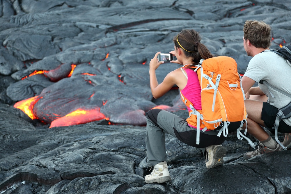 Two tourists viewing lava flow up-close at Hawaii Volcanoes National Park